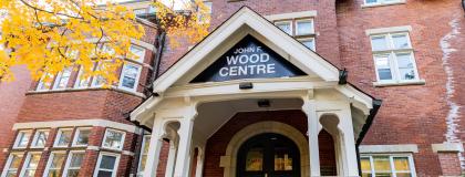 A red brick image with John F. Wood Centre text