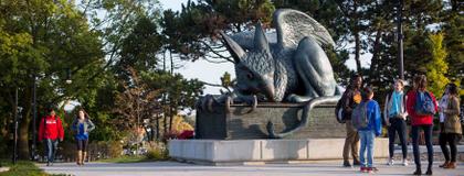 students in front of gryphon statue