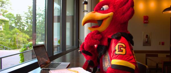 Gryph mascot on a laptop
