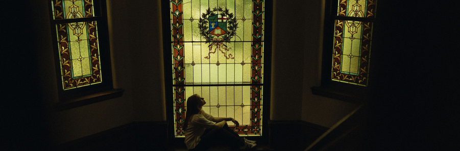 Student sitting in front of stained glass