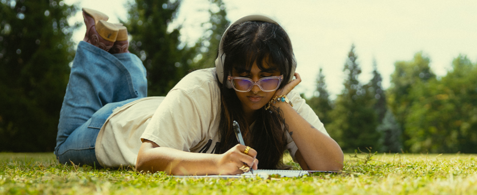 Student laying on Johnston green and studying