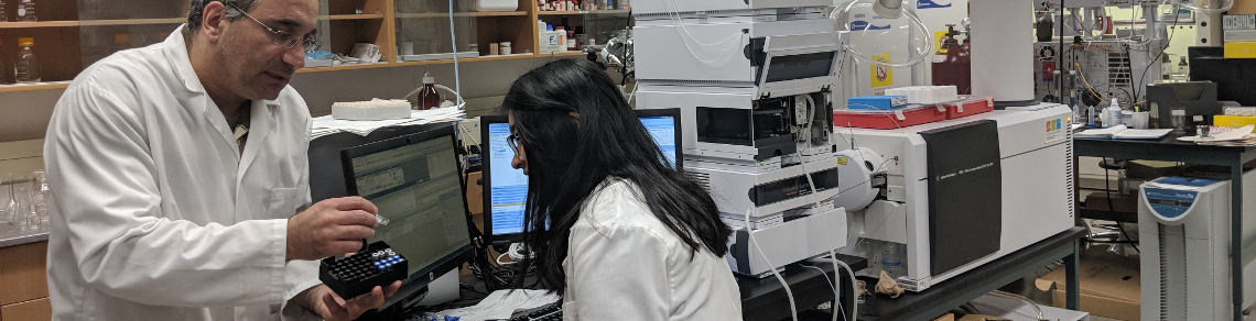 Image of Dr. Armen Charchoglyan helping a student perform mass spectrometry analysis