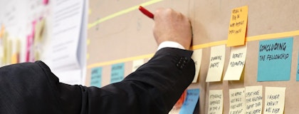 man writing on post-it notes