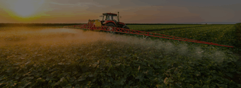 Tractor with sprayer moving through crops