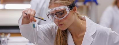 Chemistry student analyzing test tube in a lab.