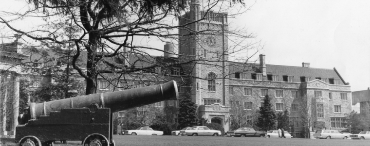 A historic photo of Johnston Hall with "Old Jeremiah" the cannon perched in front, on Johnston Green