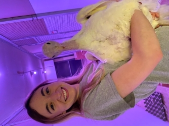 Clara Ziezold holding a turkey, standing in a hallway bathed in red LED light