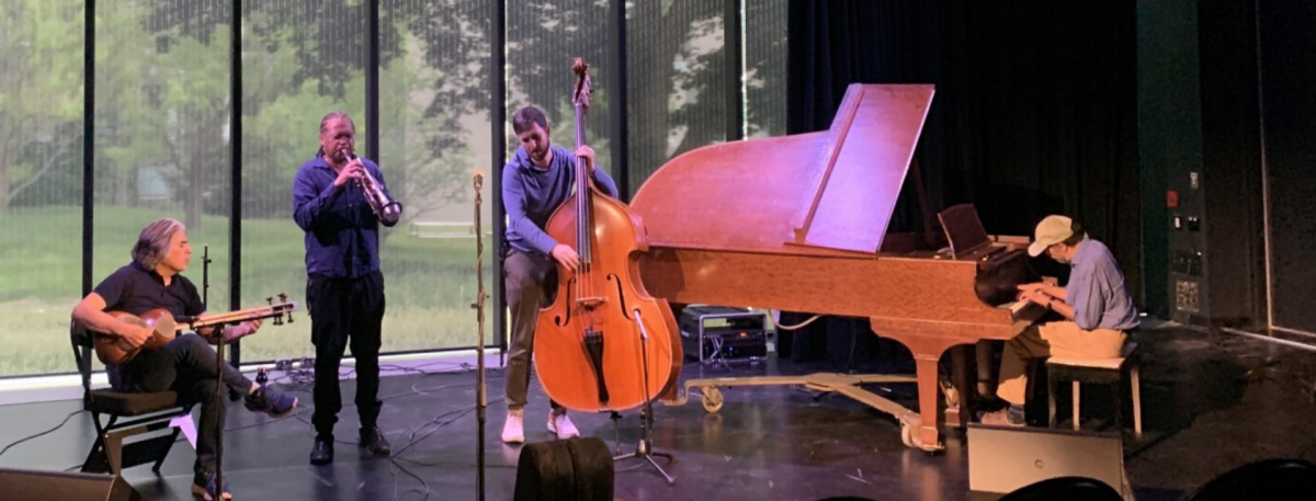 Four people on stage performing with musical instruments in the improvisation lab at the University of Guelph