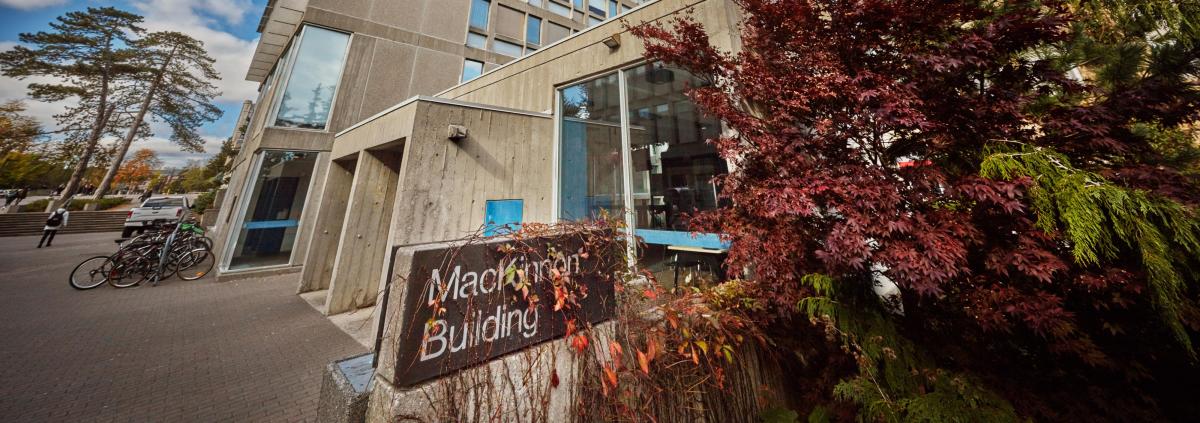 Mackinnon against a clear sky, surrounded by lush green bushes.