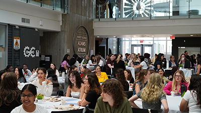 Group of attendees sitting at tables in the Adams Atrium.