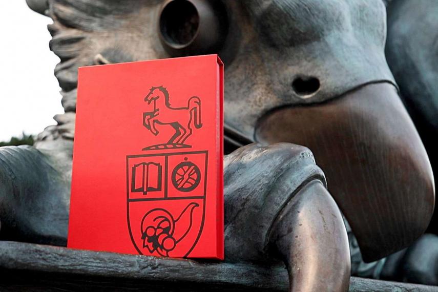 Image of Guelph Gryphon statue with graduation booklet resting on foot