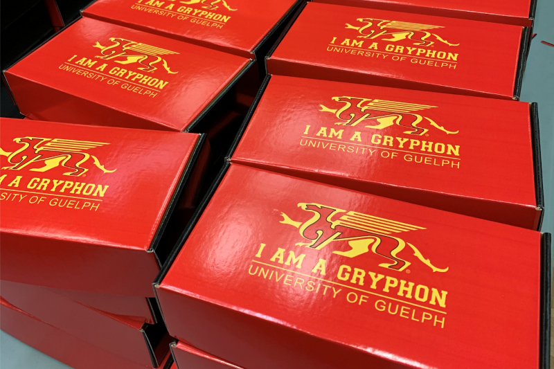 Image of orientation week boxes, which are red with the U of G Gryphon and "I am a Gryphon" printed on them