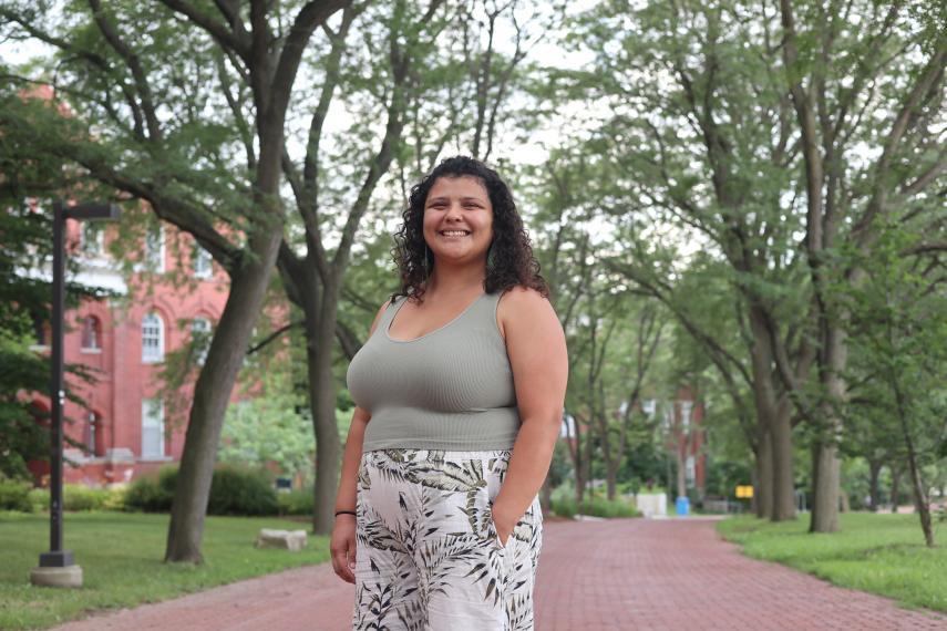 Image of Genievieve Borg standing on alumni walk smiling at camera