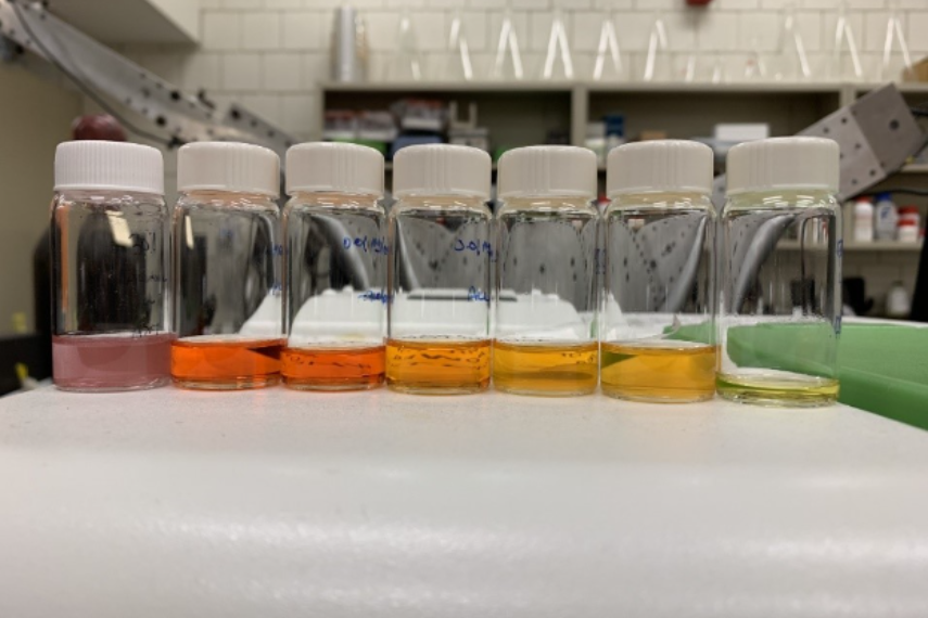 Chemical vials with red, orange and yellow liquid in order.