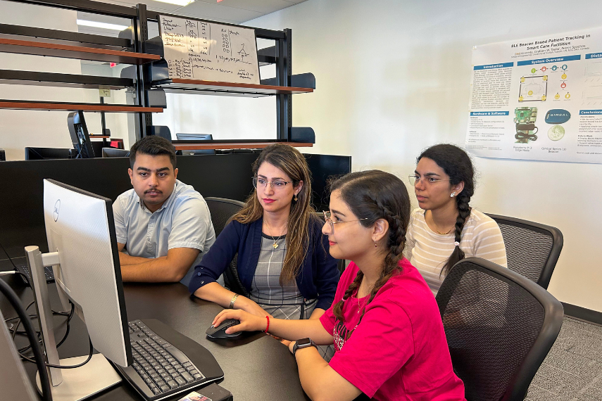 Four researchers looking at a computer.