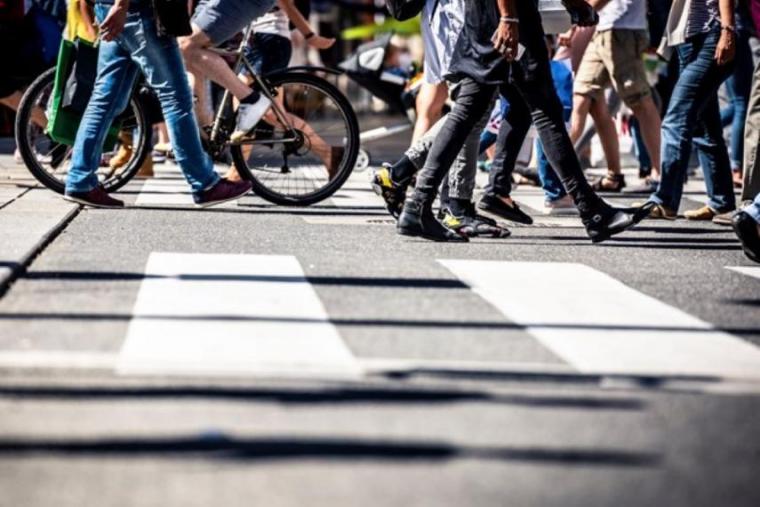 Image of a crowd of people crossing the street, only visible from the waist down