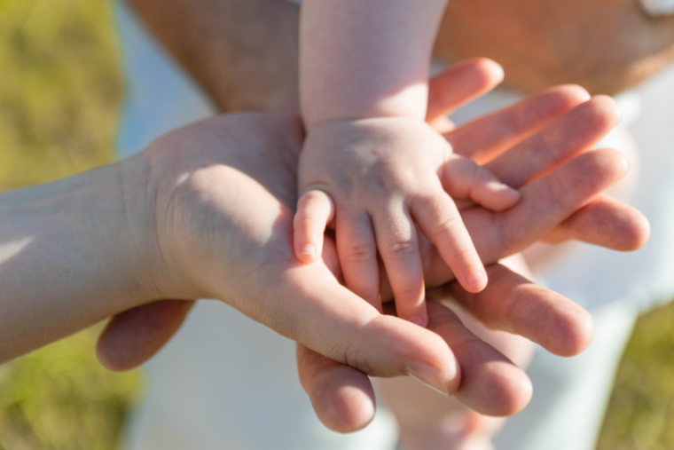 Baby hand in his mother's hand.