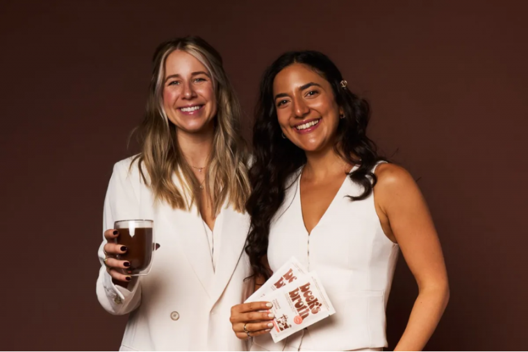 Beckie Prime and Domenique Mastronardi holding their product and smiling at the camera.