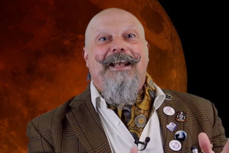 The Great Orbax in front of a red moon screen. 