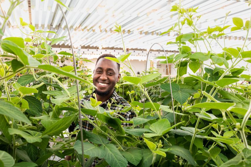 OAC Plant Agriculture PhD graduate Deus Mugabe smiling with greenery surrounding him. 