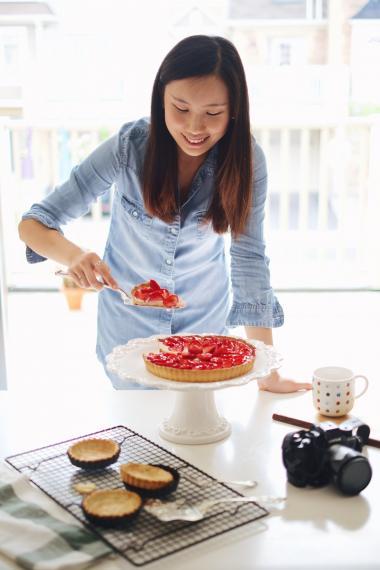 Elaine Li cutting a pie in a kitchen