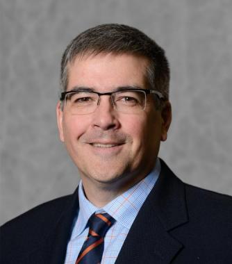 john cranfield wearing a tie and suit and glasses