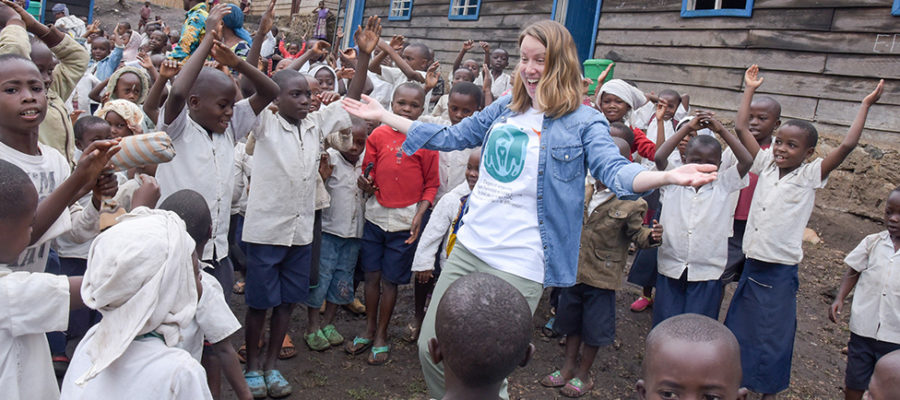 Happy young woman surrounded by African children