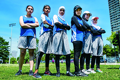six members of the Hijabi Ballers standing on the field
