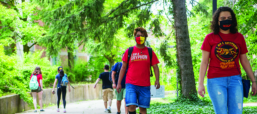students walking 6 feet apart on campus while wearing masks