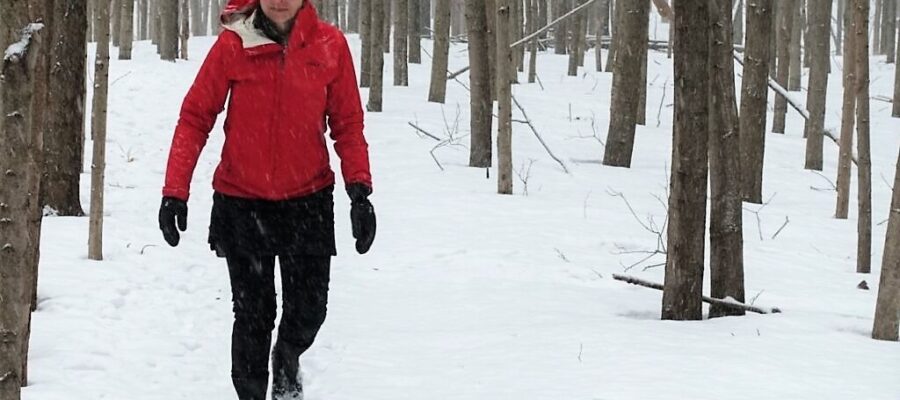 woman walking in snowy woods