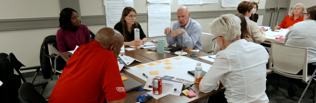 Participants seated at a table having a discussion