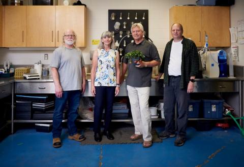 Mike Dixon and his team standing together with Mike holding a plant.