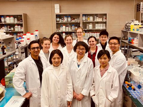 A group of researchers posing together for a photo in a lab