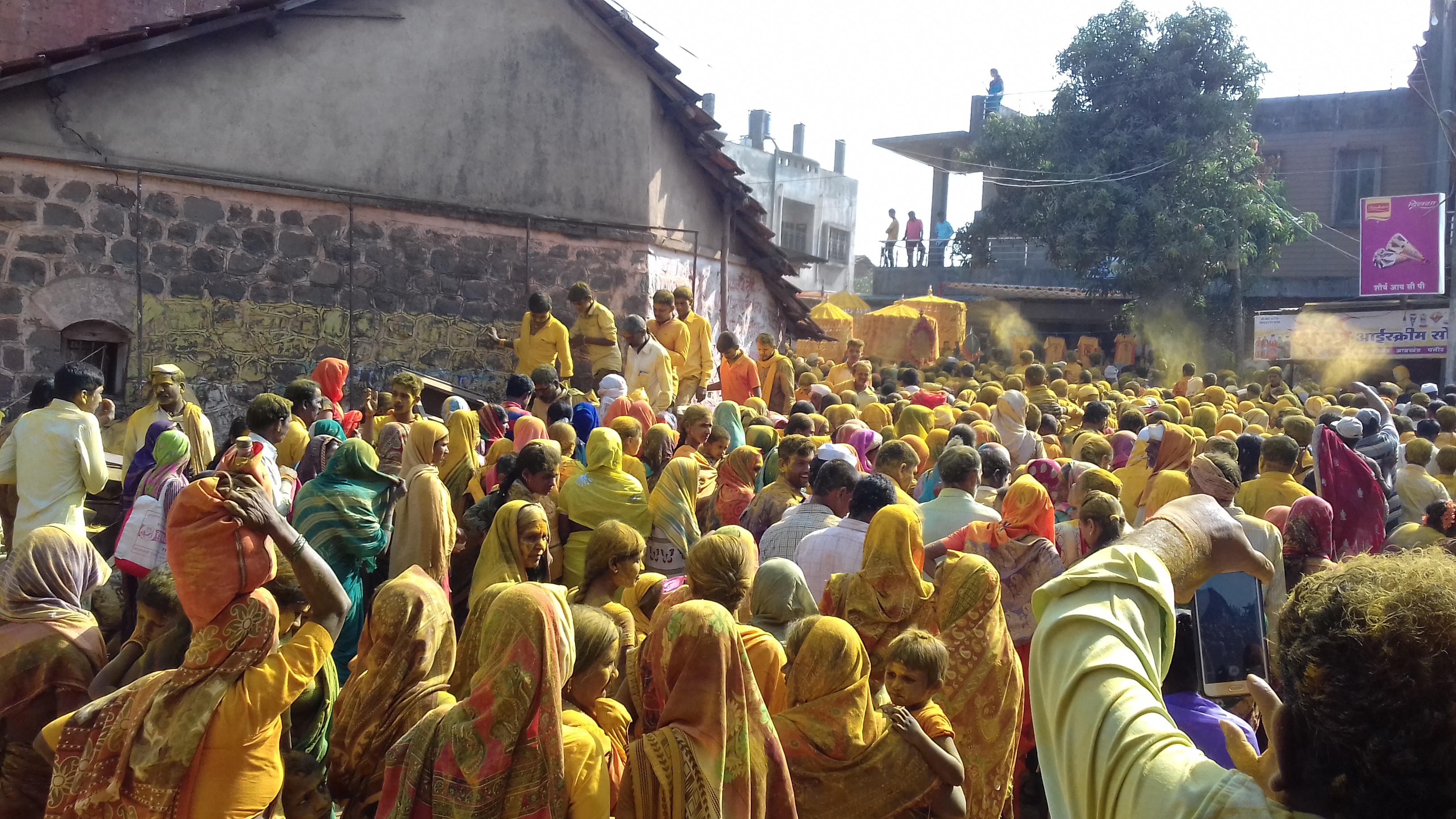 Crowds of people in yellow standing outside.