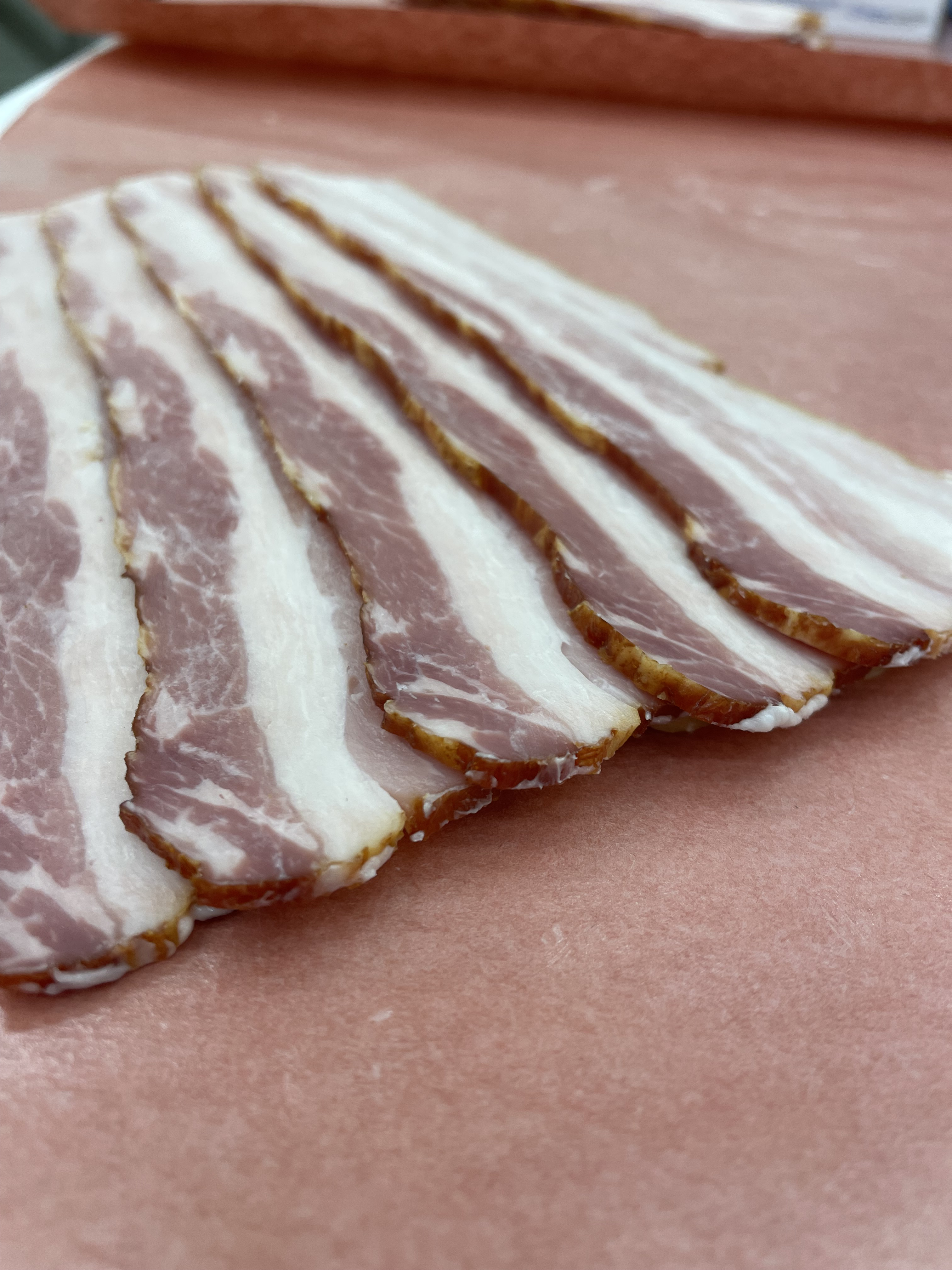 Several slabs of bacon cut up and placed in packaging