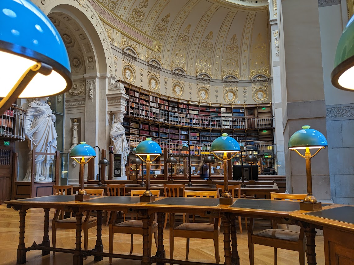 The inside of the Institut de l'Histoire de l'Art, showing large decorated ceilings, concrete statues and books