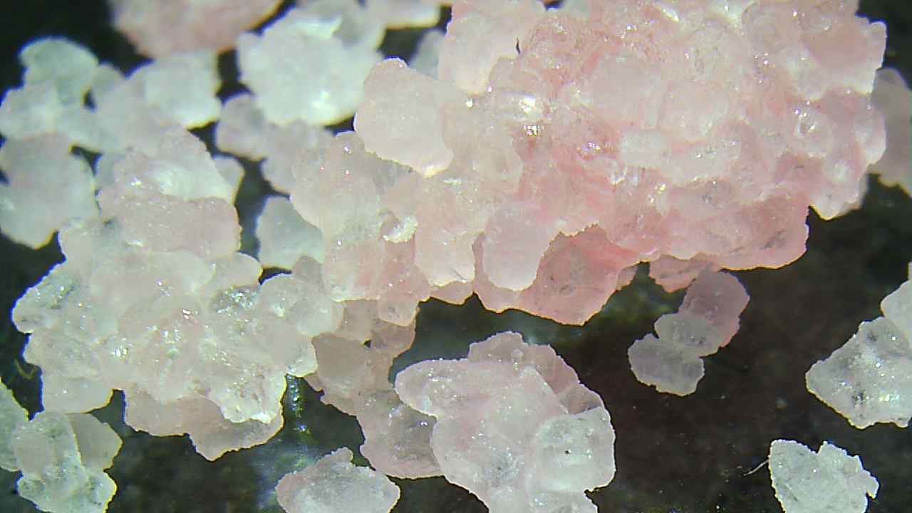  Several pink sugar crystals with a dark background