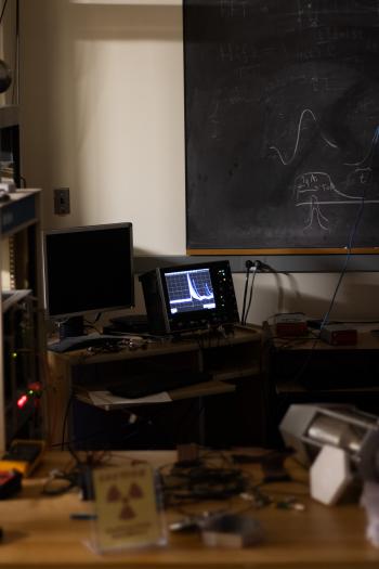 A state of the art lab with a blackboard, a computer and a fast-timing neutron detection device. 