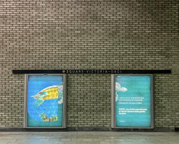 Blue advertisements and a brick wall.