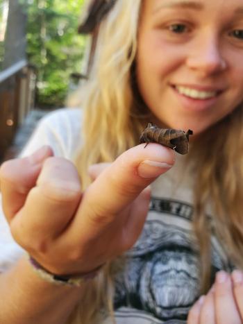 A girl with a moth perched on one of her fingers