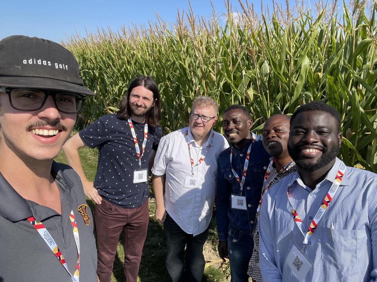 Six people standing in front of a corn field