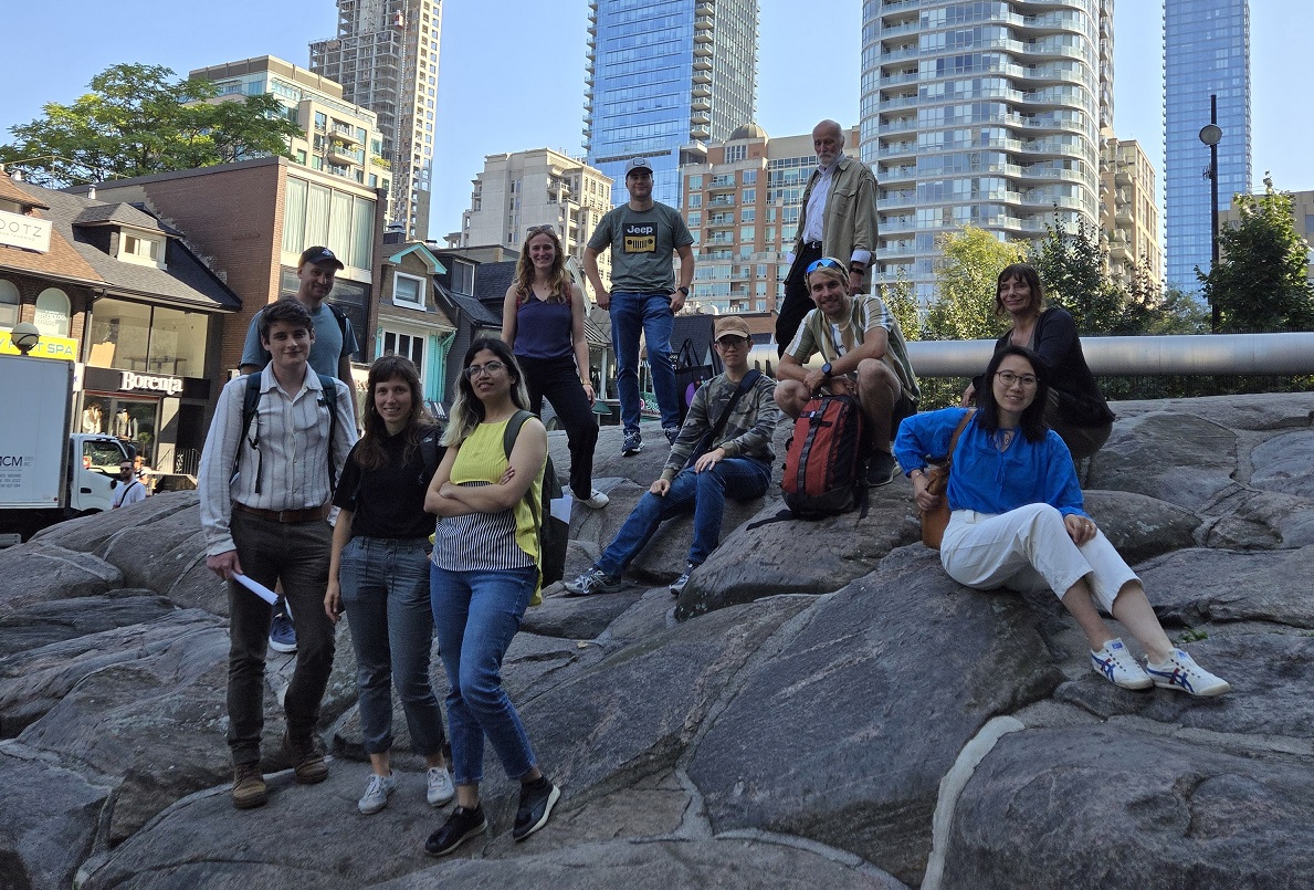 MLA students at Yorkville Park on top of rock with condos in the background