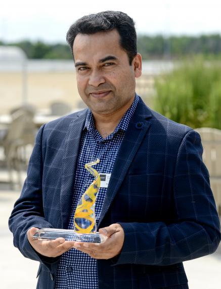 Dr. Ataharul Chowdhury holding the Early Career Research Award