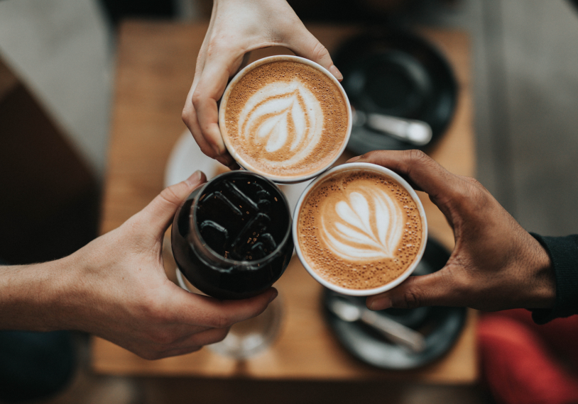 Three hands holding coffee.